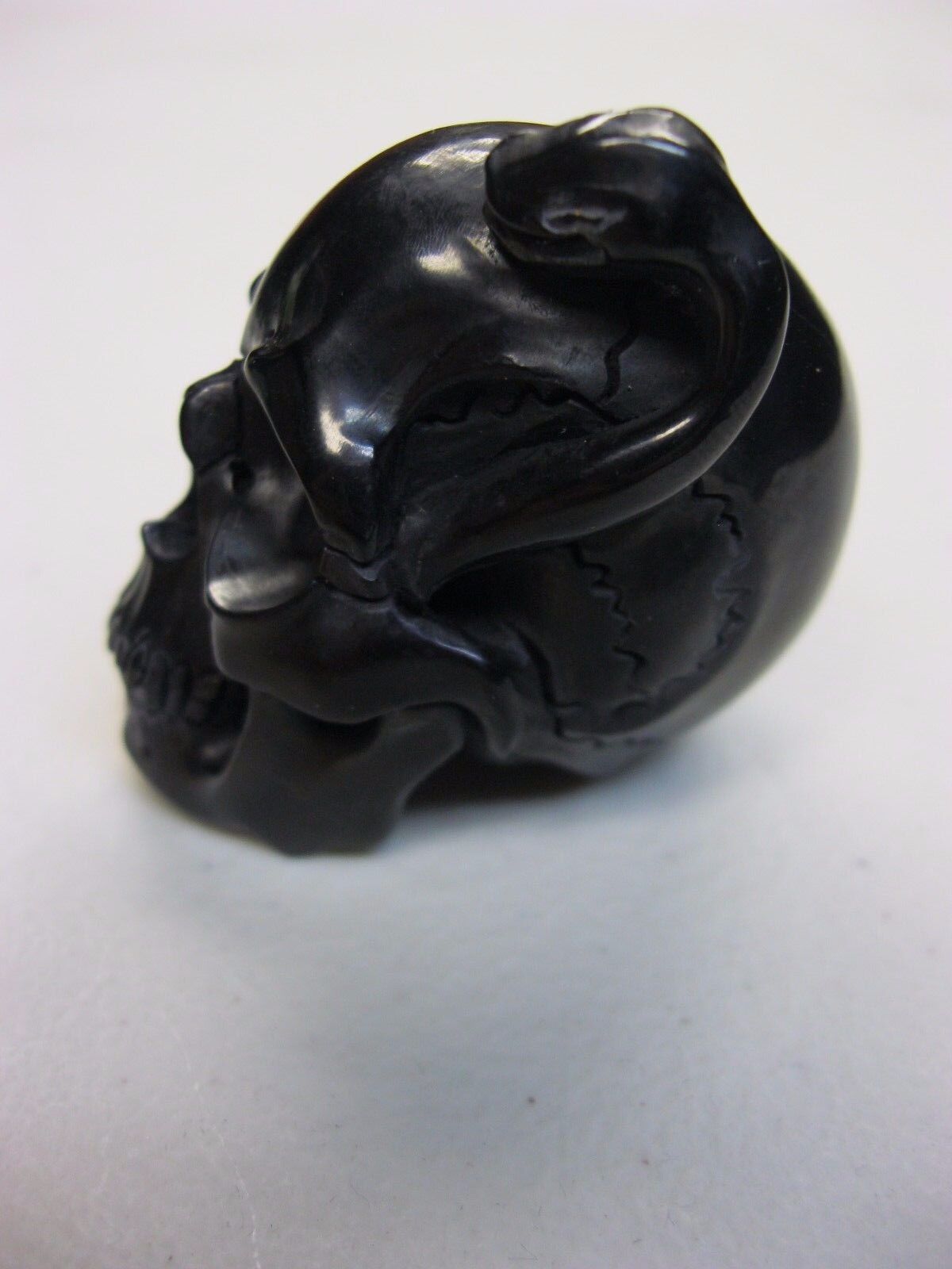 NATURAL WATER BUFFALO HORN HAND CARVED HUMAN SKULL AND SNAKE APPROX 1-1/2"