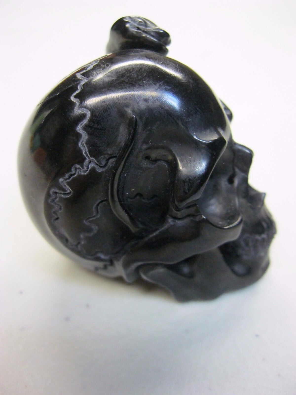 NATURAL WATER BUFFALO HORN HAND CARVED HUMAN SKULL AND SNAKE APPROX 1-1/2"